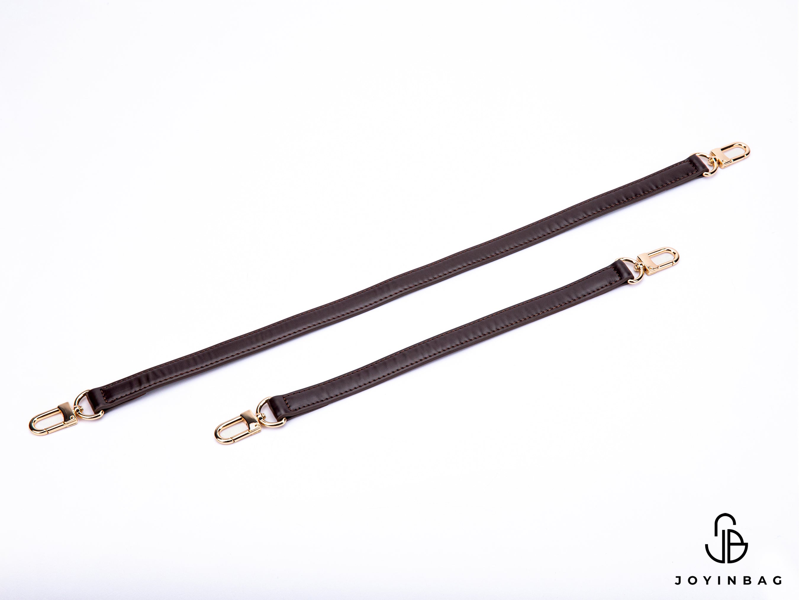 A gold or silver leather strap in a dark brown vachetta color replaces the bag's shoulder or hand straps.